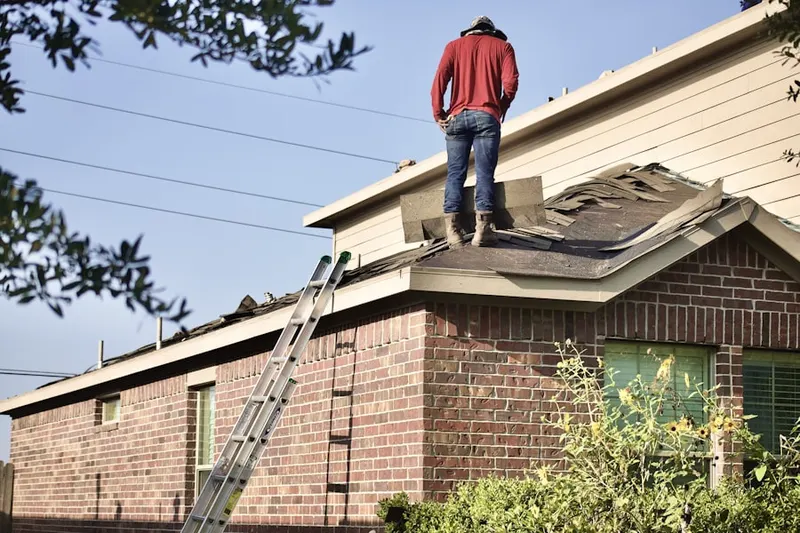 Professional roofer working on a residential roof in Herron